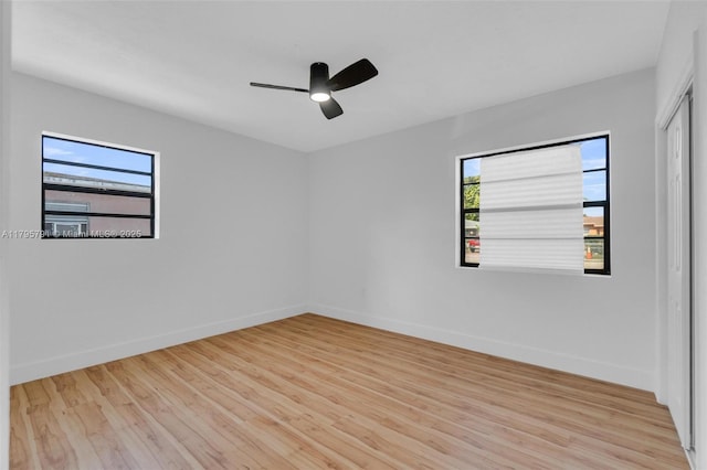 empty room featuring baseboards, ceiling fan, and light wood-style flooring
