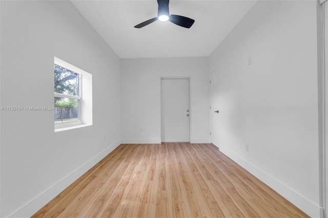 empty room with wood-type flooring, a ceiling fan, and baseboards