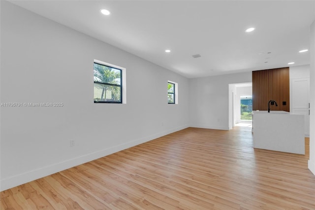 unfurnished room with recessed lighting, light wood-style flooring, and baseboards