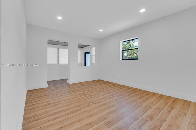 spare room featuring recessed lighting, baseboards, and wood finished floors