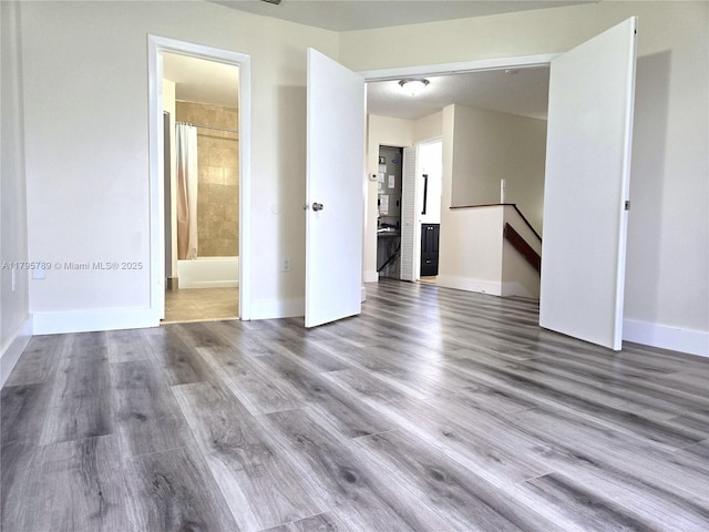 empty room with baseboards and wood finished floors