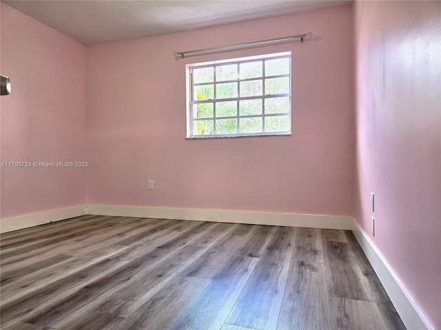 empty room featuring baseboards and wood finished floors