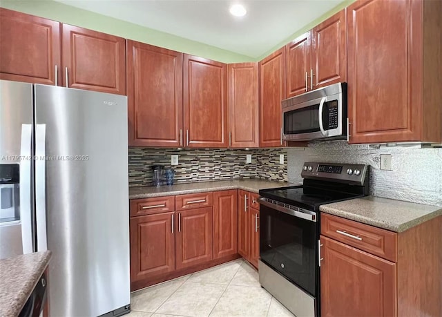 kitchen with light tile patterned floors, appliances with stainless steel finishes, backsplash, and dark countertops