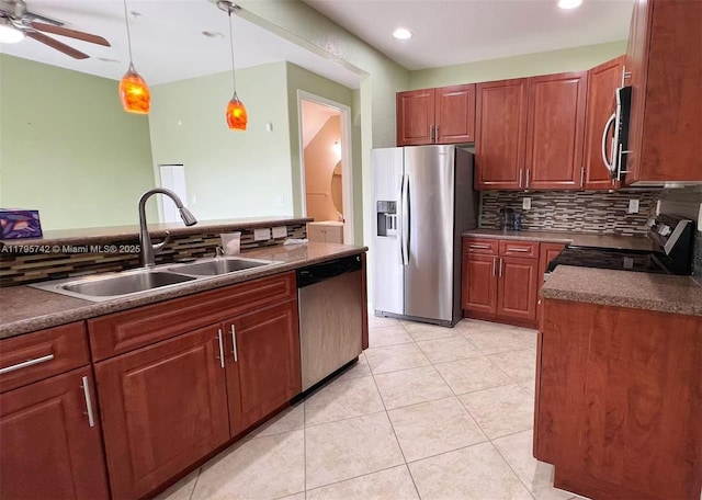 kitchen with a sink, dark countertops, decorative backsplash, and stainless steel appliances