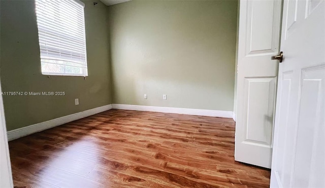 unfurnished room with baseboards and wood finished floors