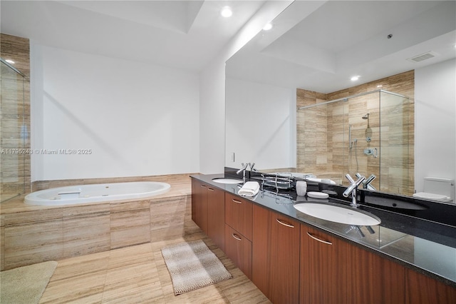 bathroom with a sink, double vanity, a stall shower, and a garden tub
