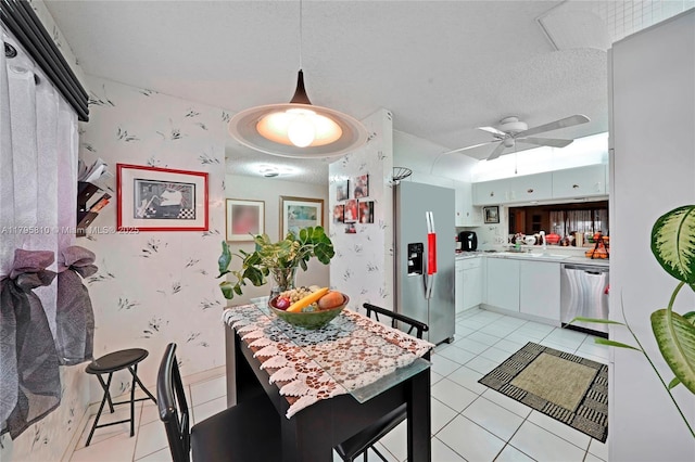 kitchen featuring appliances with stainless steel finishes, light countertops, light tile patterned flooring, ceiling fan, and white cabinets