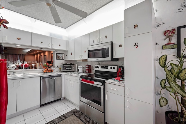 10217 NW 24th Pl Unit 107, Sunrise, FL 33322 - kitchen featuring appliances with stainless steel finishes, light tile patterned floors, light countertops, and a ceiling fan