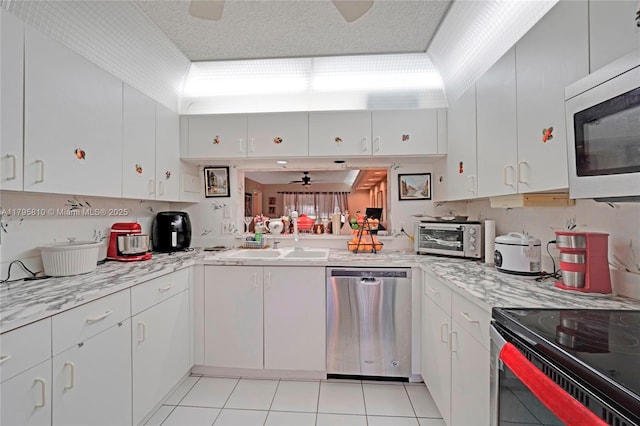 10217 NW 24th Pl Unit 107, Sunrise, FL 33322 - kitchen with stainless steel dishwasher, a ceiling fan, electric stove, light tile patterned floors, and white cabinetry