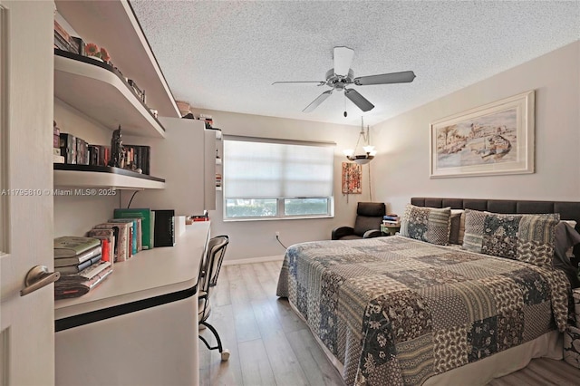 bedroom featuring a textured ceiling, light wood-type flooring, and ceiling fan