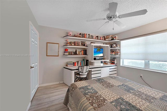 10217 NW 24th Pl Unit 107, Sunrise, FL 33322 - bedroom featuring a textured ceiling, light wood-type flooring, a ceiling fan, and a closet