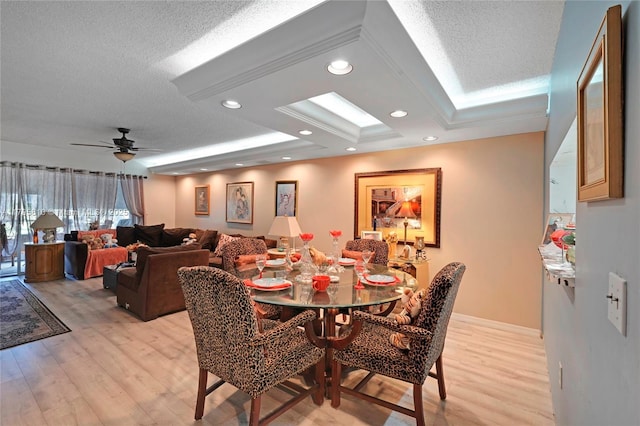 dining room with light wood finished floors and a skylight