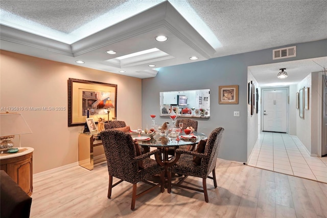 dining area featuring light wood-style flooring, recessed lighting, a textured ceiling, baseboards, and coffered ceiling