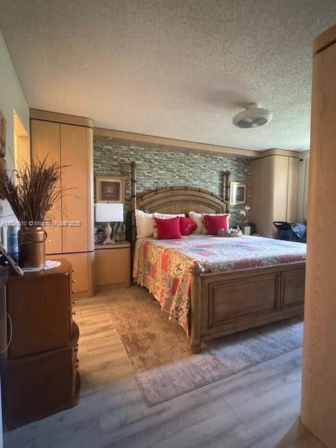bedroom featuring light wood-type flooring and a textured ceiling