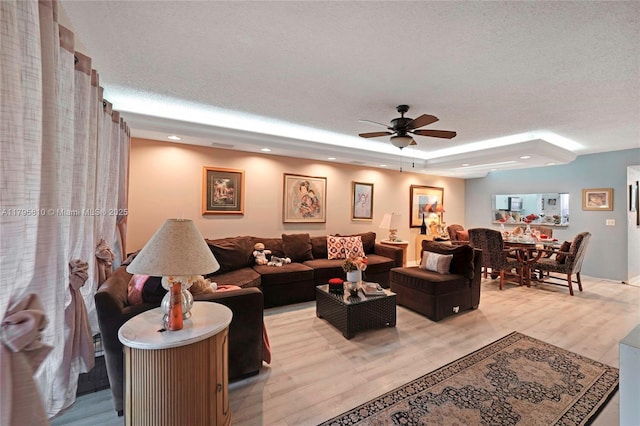 10217 NW 24th Pl Unit 107, Sunrise, FL 33322 - living area featuring a ceiling fan, light wood-style floors, a textured ceiling, recessed lighting, and a tray ceiling