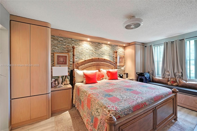 bedroom featuring a textured ceiling and light wood-style floors