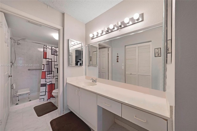 bathroom with vanity, toilet, tiled shower, and marble finish flooring