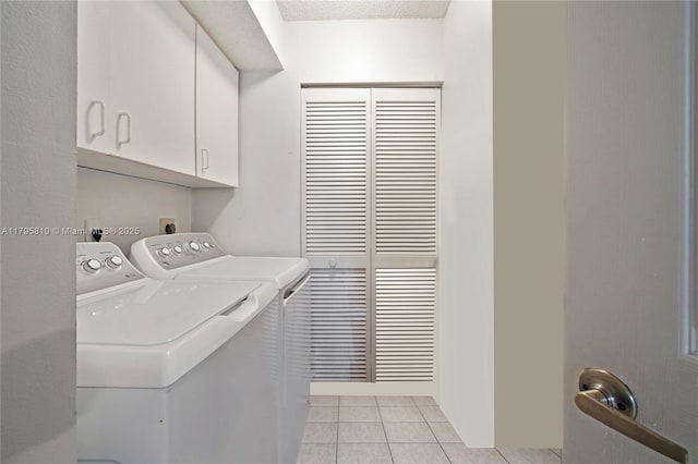 clothes washing area with cabinet space, washer and dryer, and light tile patterned flooring