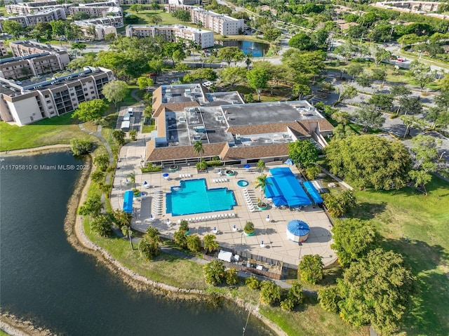 drone / aerial view of a pool area and a large body of water
