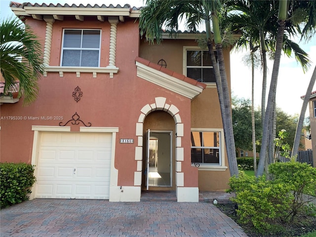 mediterranean / spanish home with a garage and stucco siding