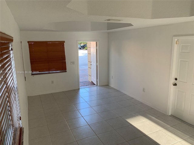 unfurnished room with tile patterned floors, visible vents, and baseboards