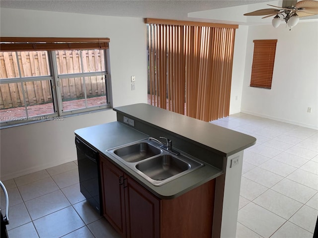 kitchen with ceiling fan, a sink, black dishwasher, light tile patterned floors, and a center island with sink