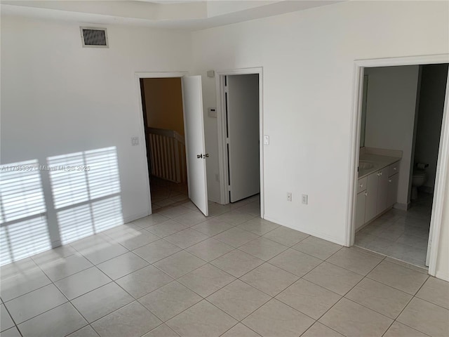 unfurnished bedroom featuring light tile patterned flooring and visible vents