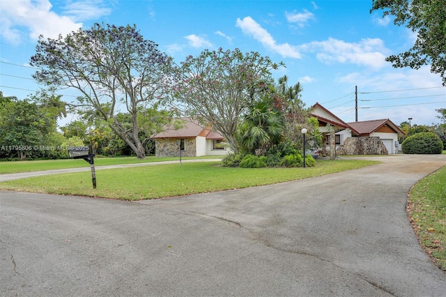 view of front of home with an attached garage, a front lawn, and driveway