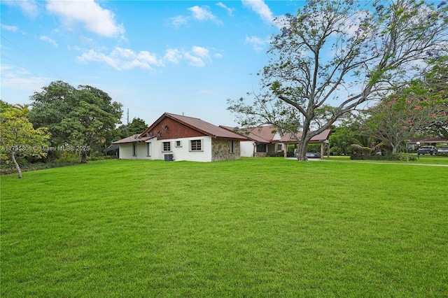rear view of house with a yard and stucco siding