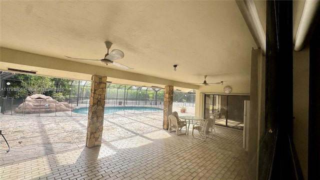view of patio / terrace featuring a ceiling fan, an outdoor pool, a lanai, and fence