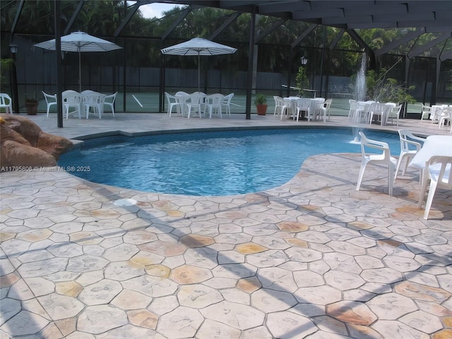view of pool featuring glass enclosure, a fenced in pool, and outdoor dining area