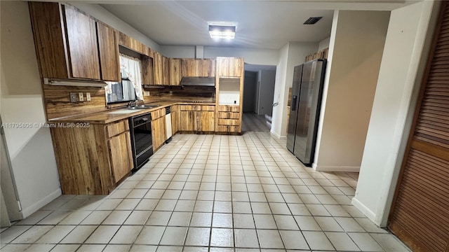 kitchen with stainless steel refrigerator with ice dispenser, visible vents, brown cabinets, baseboards, and black dishwasher