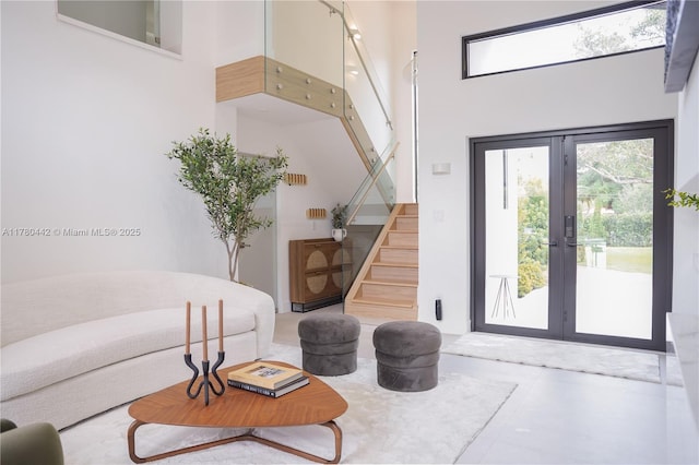 interior space featuring stairway, french doors, and a towering ceiling