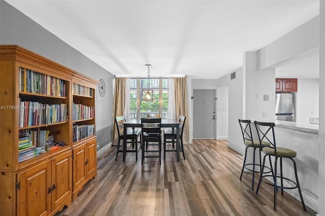 dining space featuring dark wood-style flooring, baseboards, and visible vents