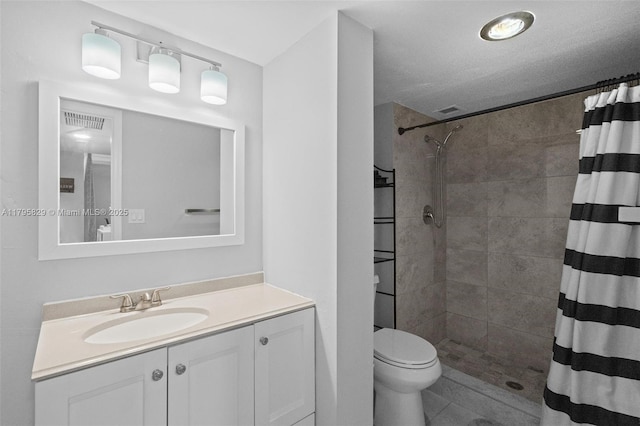 full bathroom with vanity, tile patterned flooring, toilet, and tiled shower