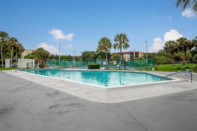 pool featuring fence and a patio area