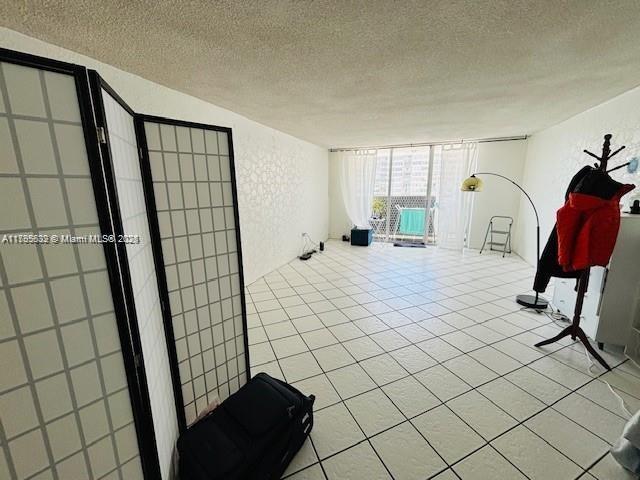 2780 NE 183rd St Unit 810, Aventura, FL 33160 - empty room with a textured ceiling and tile patterned floors