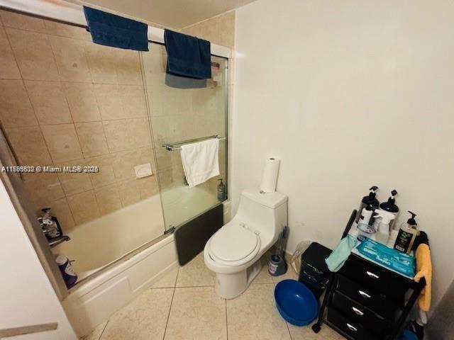 2780 NE 183rd St Unit 810, Aventura, FL 33160 - bathroom featuring tile patterned flooring, toilet, and bath / shower combo with glass door