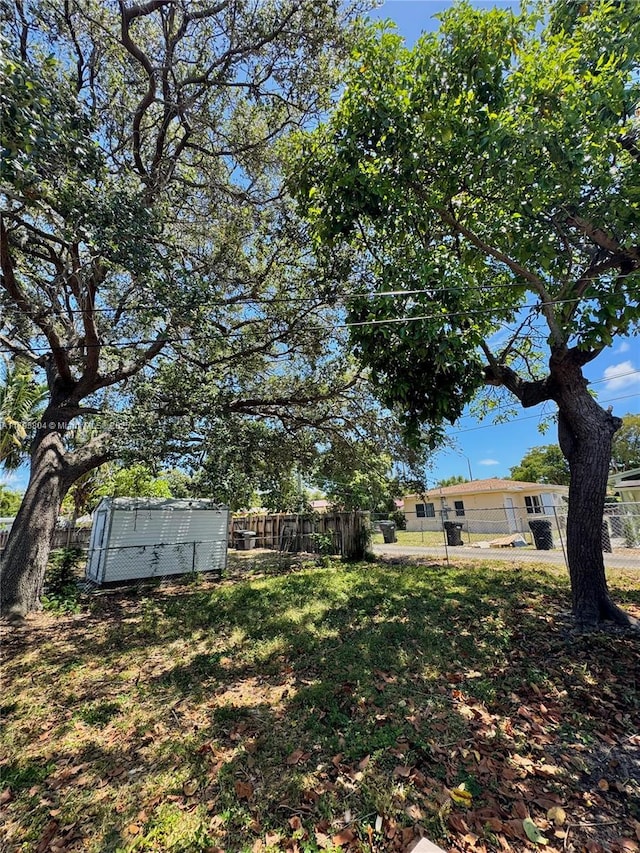 2100 NE 173rd St, North Miami Beach, FL 33162 - view of yard featuring a fenced backyard, a shed, and an outbuilding