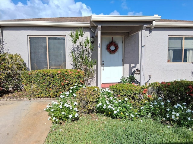 entrance to property featuring stucco siding