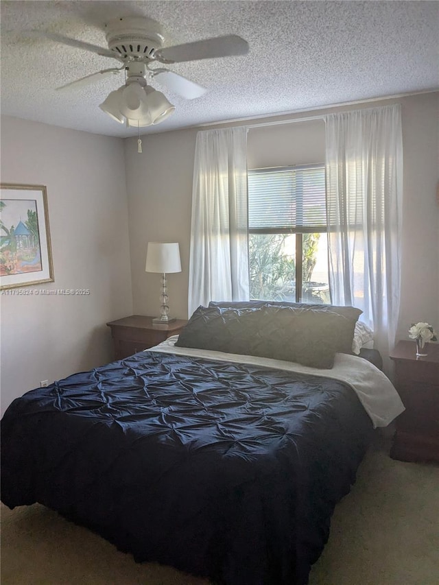 bedroom with carpet floors, a textured ceiling, and ceiling fan