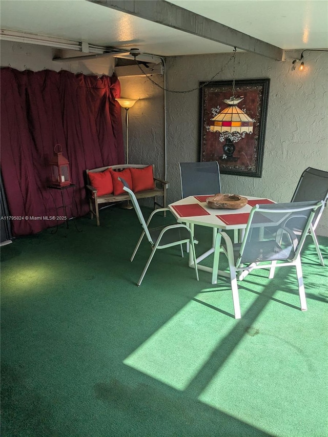 dining room with carpet floors and a textured wall