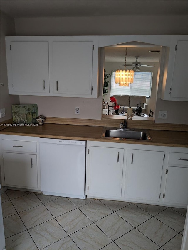 kitchen with a sink, dishwasher, a chandelier, white cabinets, and dark countertops