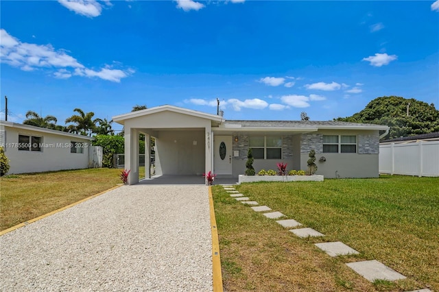 view of front of property with an attached carport, fence, driveway, and a front lawn