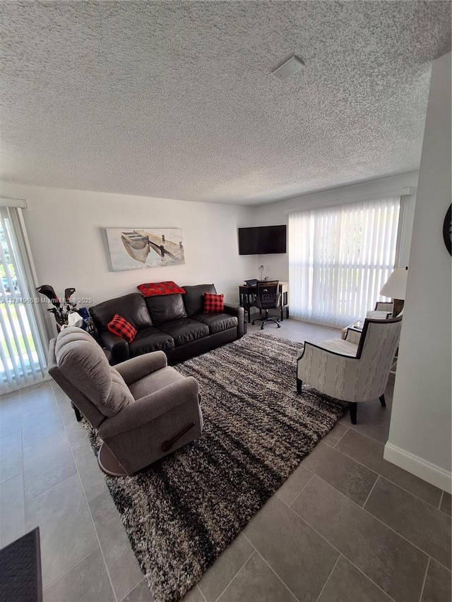 tiled living area featuring plenty of natural light and a textured ceiling