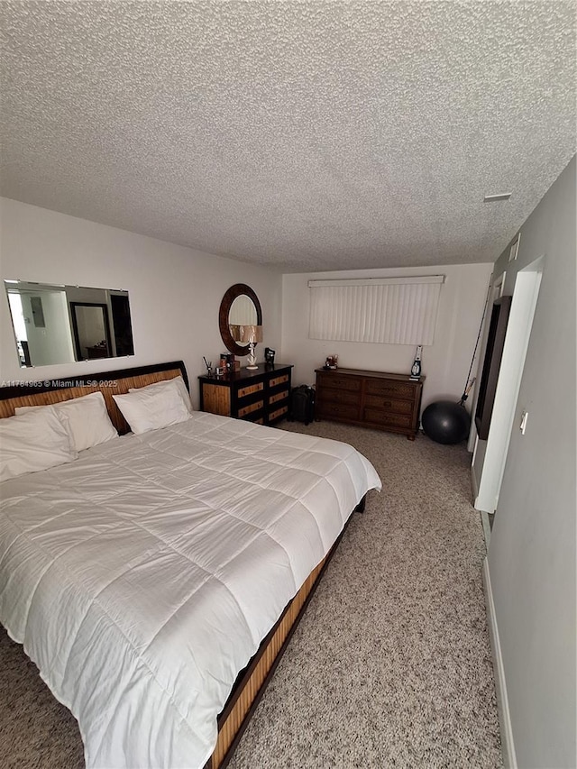 bedroom with baseboards, carpet flooring, and a textured ceiling