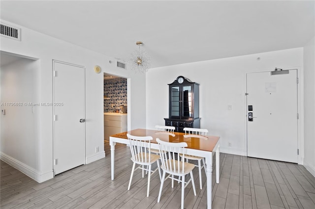 dining space featuring baseboards, visible vents, and light wood-style floors