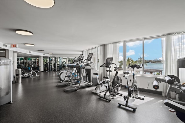 exercise room with a water view
