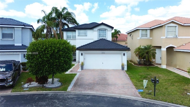 view of front of house featuring a front lawn, decorative driveway, stucco siding, a tiled roof, and an attached garage