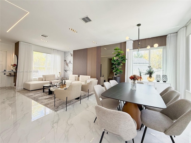 dining area with a healthy amount of sunlight, marble finish floor, and visible vents